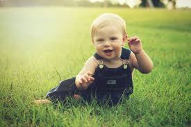 a cute baby laughing on grass